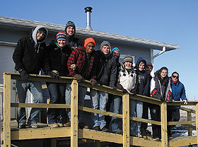 A group of students on a wheelchair ramp they constructed at Arlene High Horse’s house on Pine Ridge Indian Reservation in South Dakota during spring break.