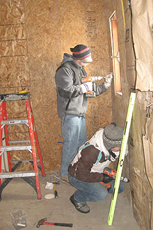 Bryan Banville, standing, a UConn student, and Kimberly Burfield of James Madison University, work at Bob Bear Killer's house on Pine Ridge Indian Reservation during spring break.