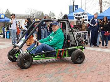 President Michael Hogan drives a fuel cell-powered go-kart built by the Connecticut Global Fuel Cell Center during a celebration of Earth Day on April 22.