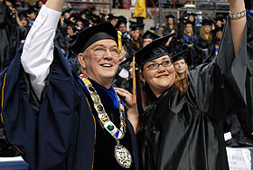 President Michael J. Hogan and graduate Meghan Perrone at the College of Liberal Arts and Sciences Commencement ceremony at Gampel Pavilion. 