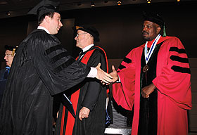 Dental student Tony D'Occhio accepts a congratulatory handshake from Dr. Cato T. Laurencin, vice president for health affairs and dean of the UConn School of Medicine.