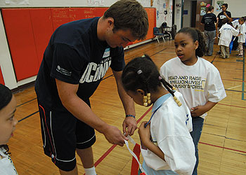 UConn junior Zach Fraser with students at Clark Elementary and Middle School Academy, during a Husky Sport fund raiser on May 1.