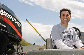 Jason Vokoun, assistant professor of natural resources and the environment, in a boat at Spring Manor Farm.