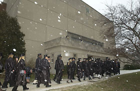 Image: Snow falls as students walk to Jorgensen Center for the December commencement.