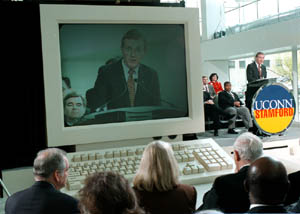 Pres. Austin appears on a mock computer screen as he speaks at Stamford